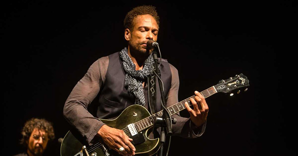 Portrait de Gary Dourdan, artiste et acteur, lors d’une performance guitare à la main.
